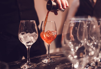 Male barman is making cocktail at night club