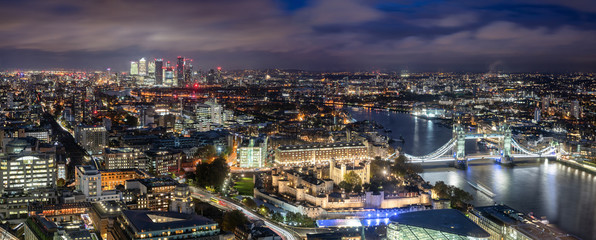 Luftaufnahme der Tower Brücke und des Towers von London am Abend mit dem Finanzbezirk Canary Wharf...