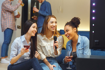 Group of friends having party indoors fun together girls laughing