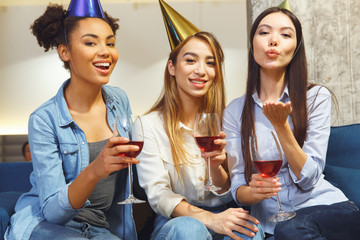 Group of friends having party indoors fun together air-kiss