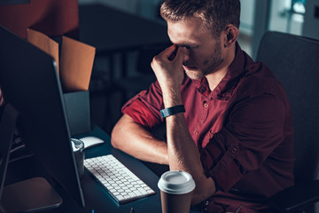 Tired man after work day in his office