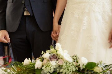 Brautpaar h&auml;lt sich an den H&auml;nden w&auml;hrend des Ja Wortes