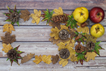 Beautiful autumnal decoration with leaves on wooden background 
