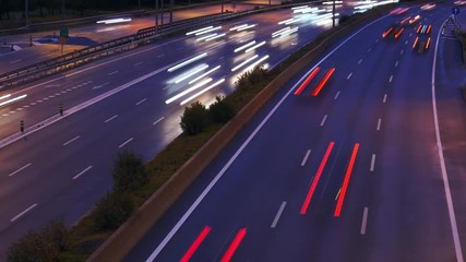 Timelapse of car traffic jam at busy highway long exposure light trails during evening to night transition