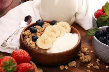 Tasty homemade granola served on table. Healthy breakfast with a bowl of oatmeal with banana, blueberries, strawberries and healthy food for Breakfast