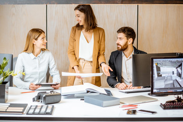 Small group of creative office employees working together on some architectural project in the modern office. Concept of an architectural business and creative work