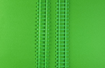 Toy railway rails on green background. Top view