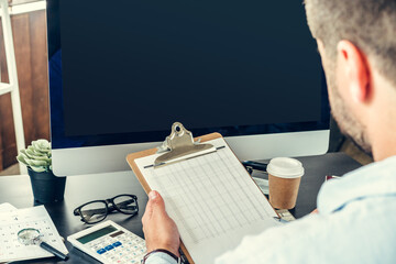 Young man businessman sitting at his working table in office