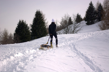 the woman goes up the mountain with the sled