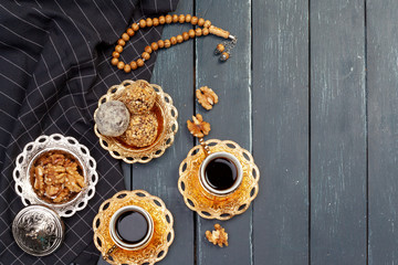 Nut balls dessert served with coffee on dark wooden table, top view