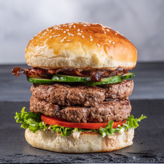Homemade burger on a stone plate.