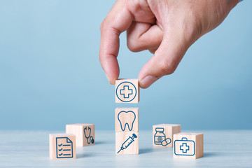 Health and Medical Plan Concept : Hand arranging wood block stacking with icon healthcare medical. Health retirement plan. COPY SPACE.
