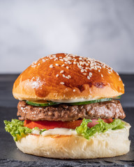 Homemade burger on a stone plate.