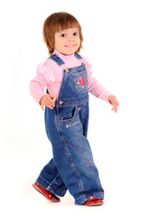 Small girl in jeans jumpsuit walking and smiling