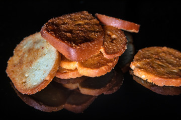 Mini bruschettes with spices with reflection on shiny black background