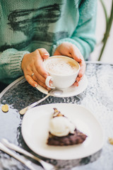 Two cups of cappuccino and two brownie desserts.