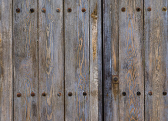 Obraz premium Old door with textured wooden planks and in gray tones of an abandoned house.