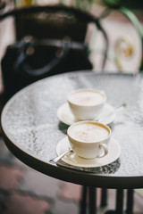 Two cups of cappuccino and two brownie desserts.