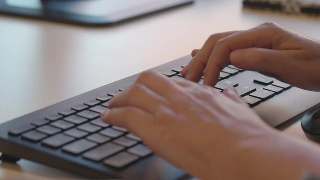Close of woman hands typing at a computer keyboard