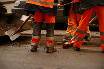 Road works with men in uniform working with tools