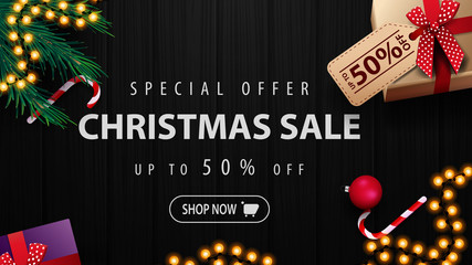 Special offer, Christmas sale, up to 50% off, discount banner with presents, Christmas tree, candy cans and black wood texture on the background