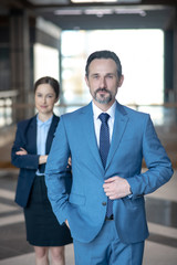 Serious bearded businessman wearing elegant suit standing in the office