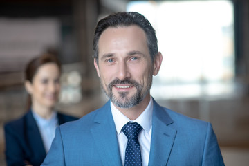 Blue-eyed mature businessman smiling while feeling happy after meeting