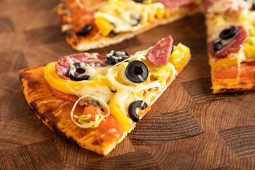 Sliced a pizza served on wooden cutting board