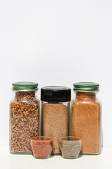 Three jars with spices of different grinding and two small bowls