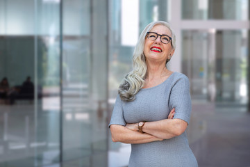 Friendly middle aged business female leader laughing, happy old businesswoman enjoying smiling, mature business coach and executive