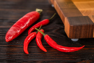 Chilli red pepper lie on wooden cutting board