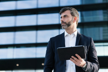 Empresario con tablet en distrito financiero