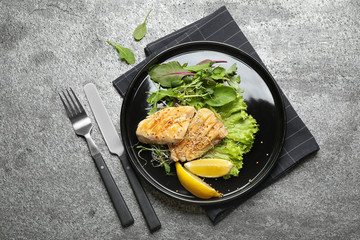 Tasty grilled fish on grey table, flat lay