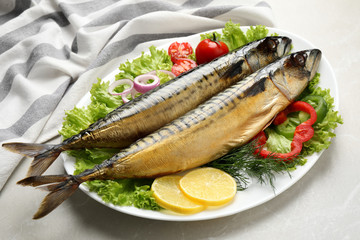 Tasty smoked fish on light grey marble table