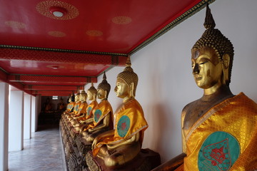Gilded statues of Buddha sitting in lotus position. Statues from a Buddhist monastery.