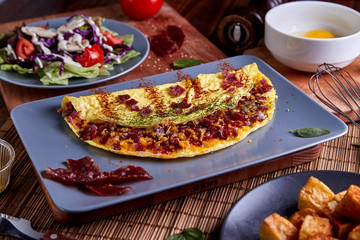 Beacon omelette with Cheese in blue plate on wood table
