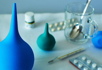 medical still life. Pills, thermometer, syringe, tube of medicine, glass Cup with a teaspoon on a white background.