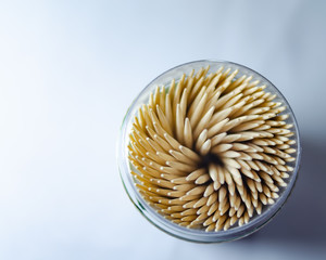 Toothpicks in a jar on a white background. Macro photo. Scattered on the table.