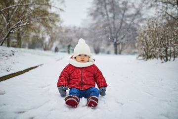 Happy smiling baby girl sitting in snow