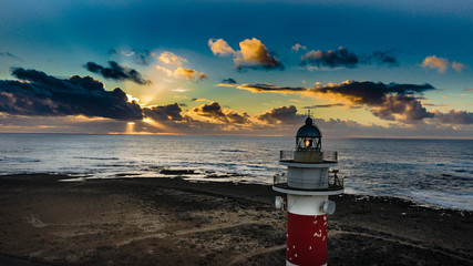 faro atardecer isla costa olas