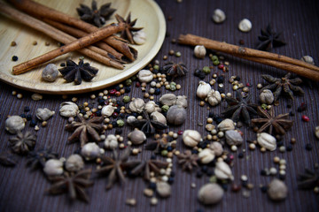 Close up star anise, cinnamon stick, cardamom and peppers on wooden plate and napkin.Photo of seasoning.