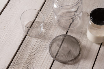 series of images to prepare milk kéfir on rustic White table