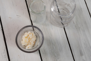 series of images to prepare milk kéfir on rustic White table