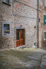 Fototapeta na wymiar Traditional street in an ancient medieval Italian town in Tuscany