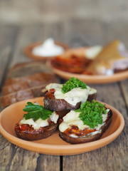 brown bread sandwiches with sun-dried tomatoes on a rustic wooden tableOLYMPUS DIGITAL CAMERA