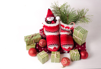 Fototapeta na wymiar Little knitted boots with Christmas gifts and various decorations
