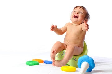 Baby sits on potty and plays toy