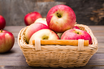 Fresh harvest of apples. Nature theme with red apples in a basket on a wooden background