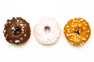 Sweet chocolate, caramel and strawberry donuts on white background isolated