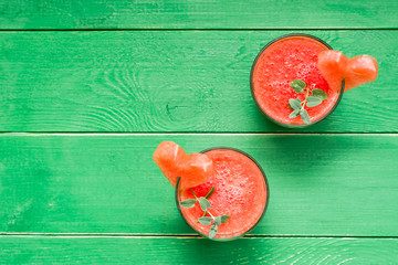 Fresh watermelon blended drink with mint leaves and a heart of watermelon in glasses on a wooden...
